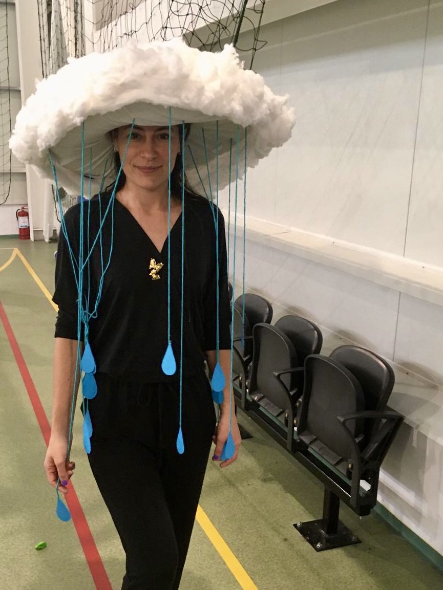 Sorina Partal într-o sală de sport a școlii, purtând un costum de nor din vată cu picături de ploaie albastre, pregătit pentru o activitate cu elevii